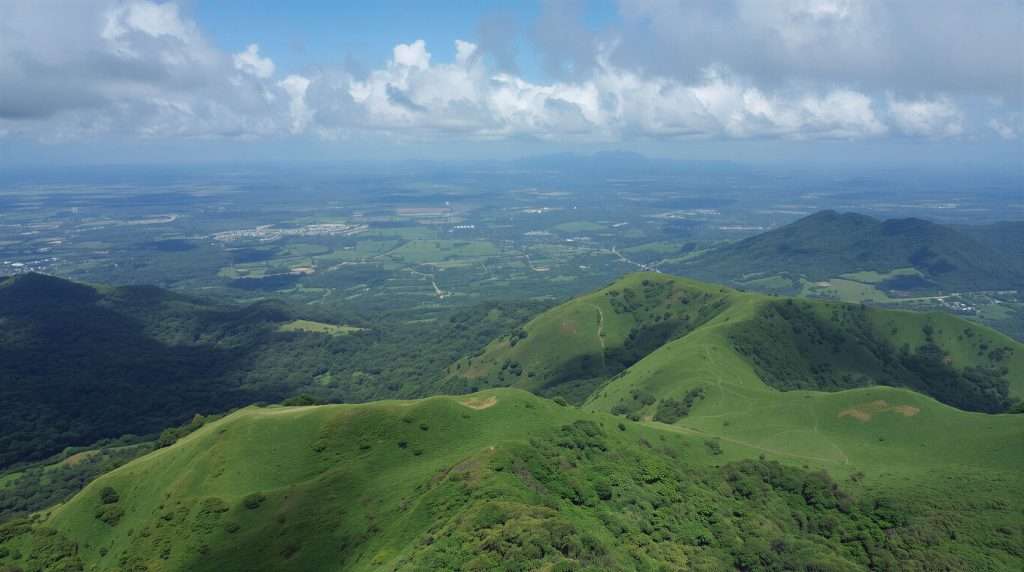 Green hills extending across a vast landscape under a cloudy sky in Brazil.