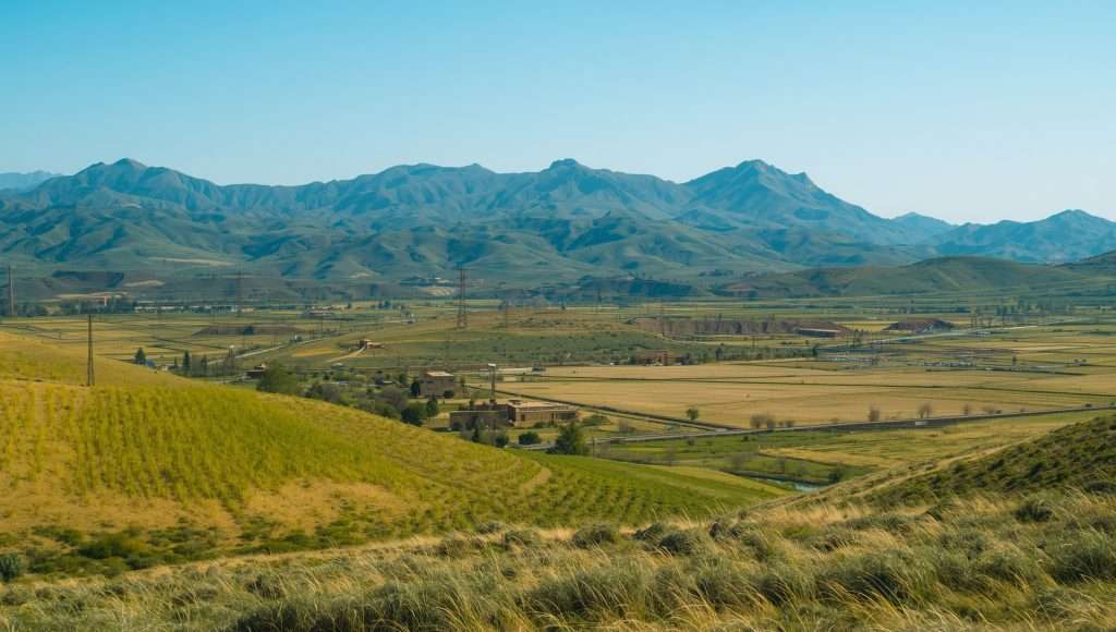 Rolling green hills and distant mountains in Uzbekistan.