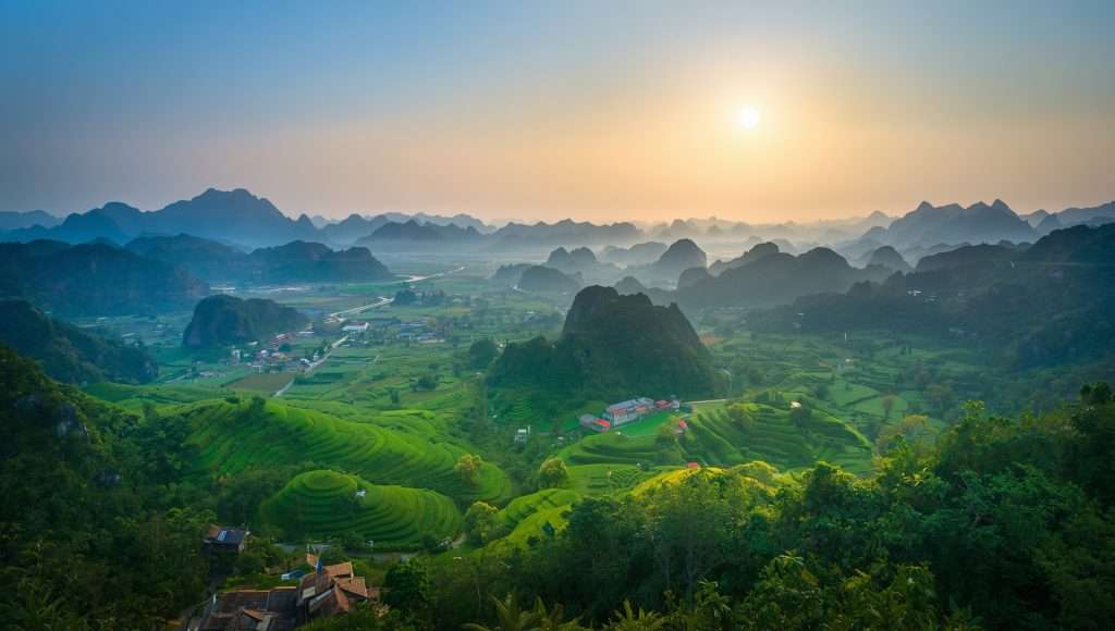 Green karst hills and misty valleys at sunrise in Vietnam.