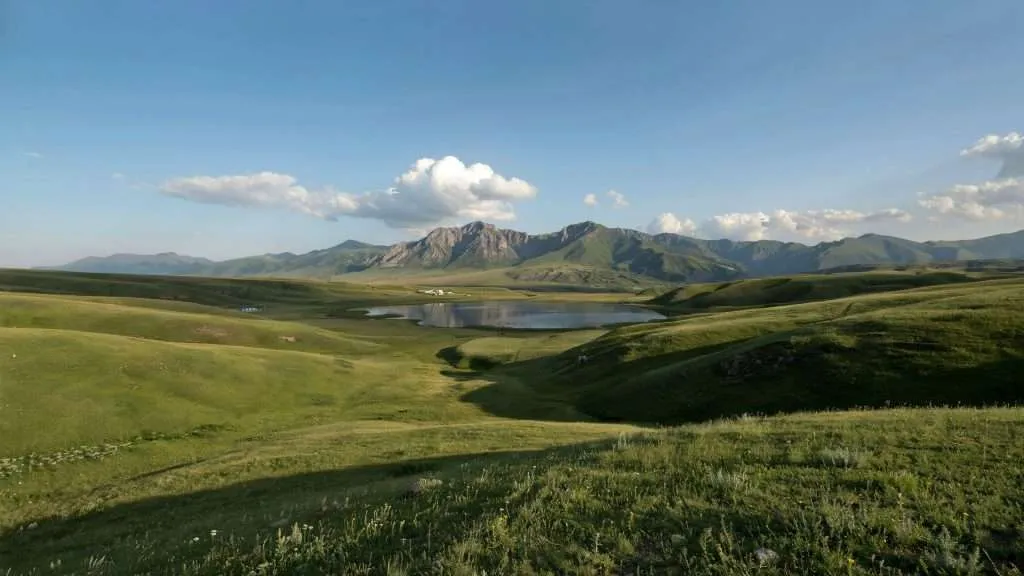 Rolling green hills with distant snow-capped mountains in Armenia.