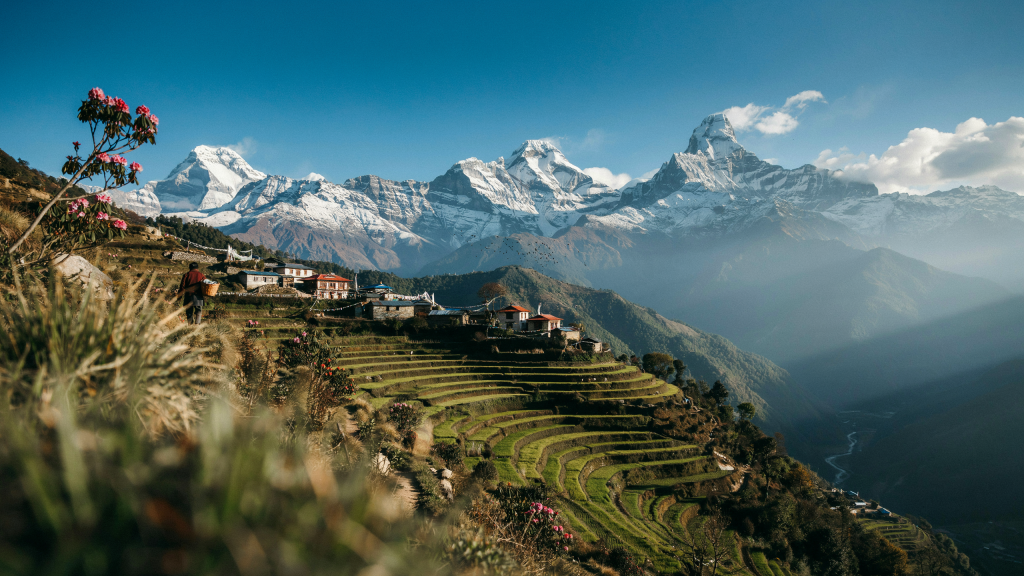 Terraced hills with houses and snow-capped mountains in Nepal.