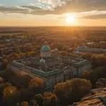 Sunset over a forested city with a domed building in Belarus.