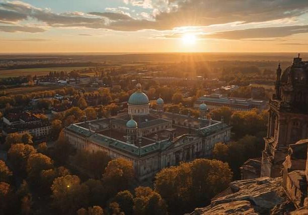 Sunset over a forested city with a domed building in Belarus.